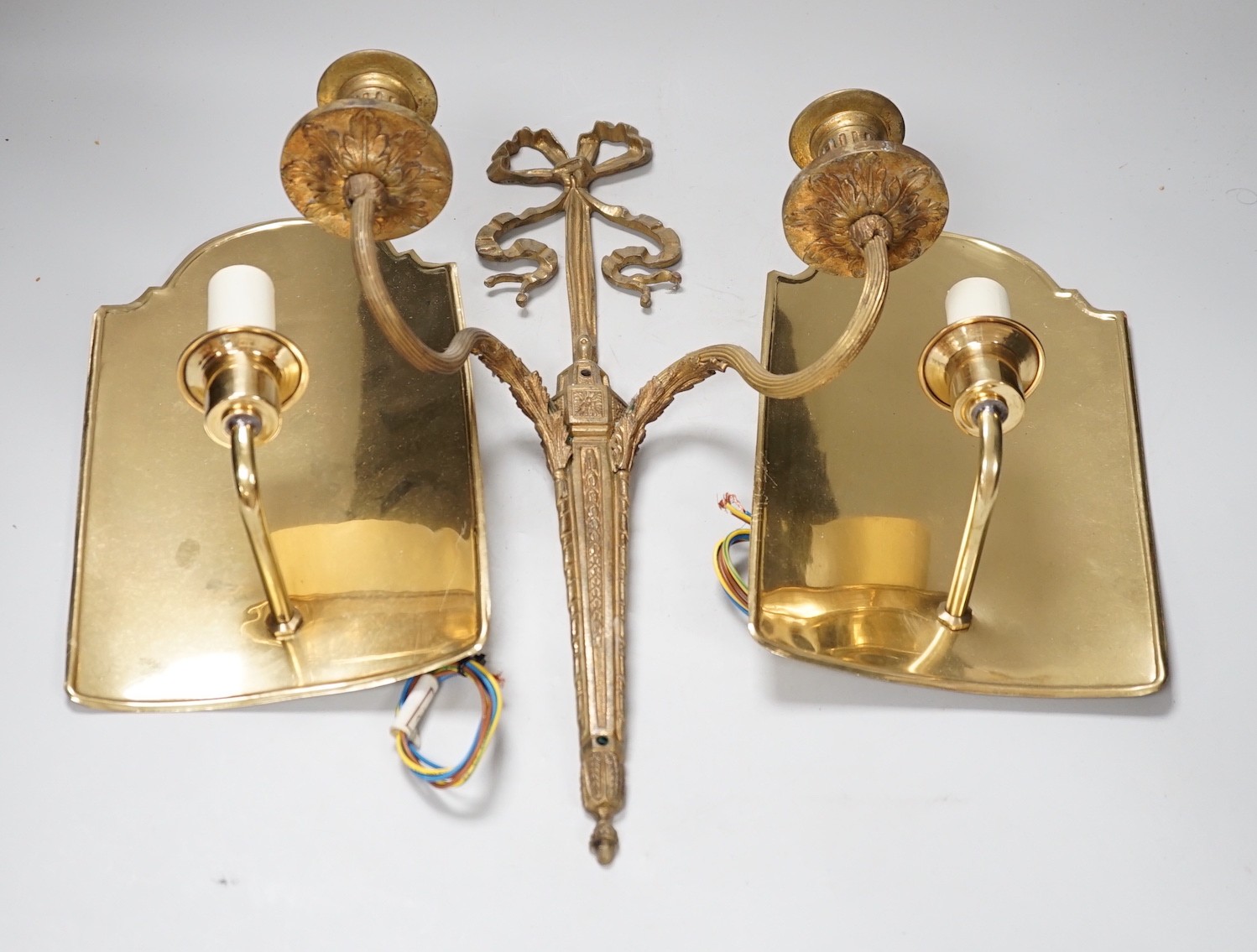 An 18th century style ribbon design brass two branch wall sconces and a pair of Dutch style brass wall lights, tallest 44cms high